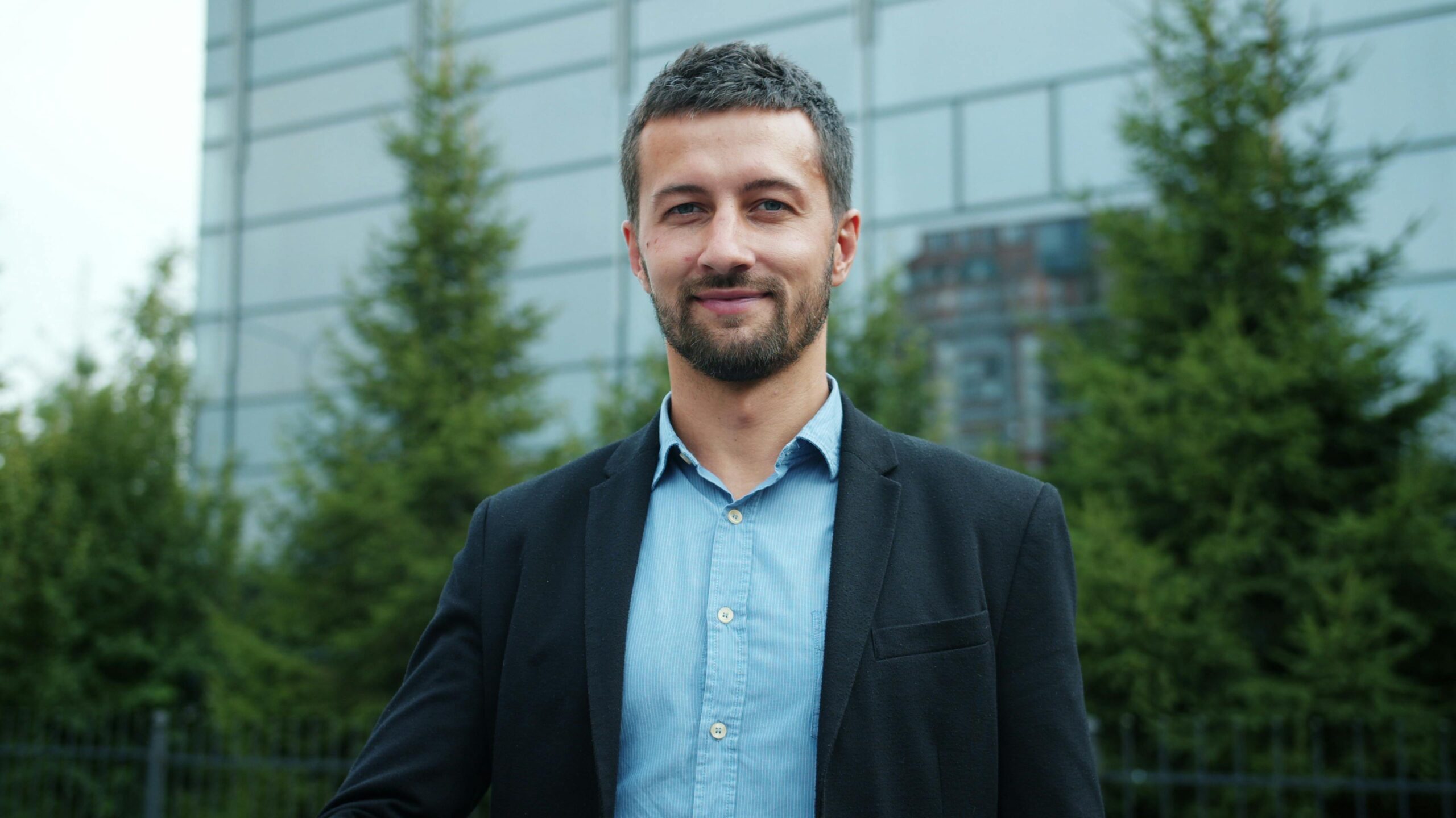 Professional man in a blazer outdoors, symbolizing success.